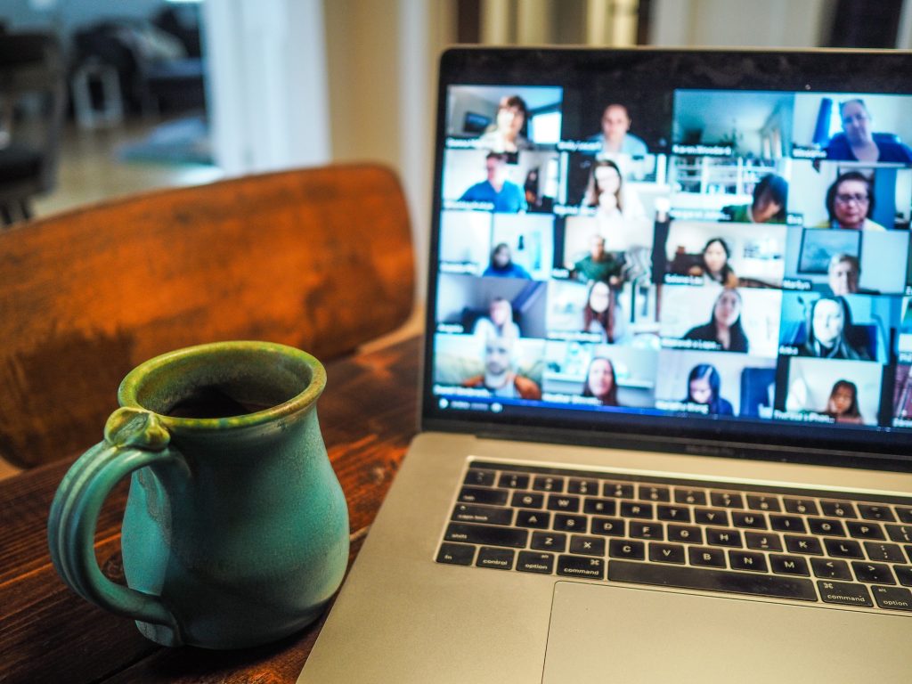 A computer screen displaying a team videoconference, with team members in separate windows participating in a virtual meeting.