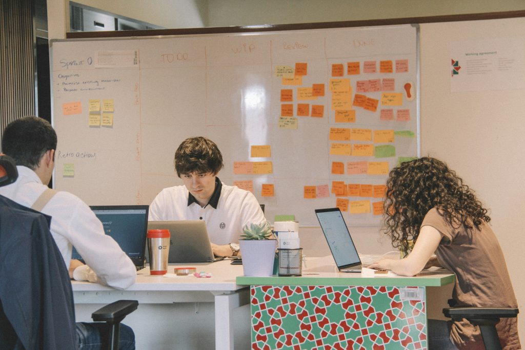 An agile team collaboratively planning and organizing their work on a board, using sticky notes and visual aids to facilitate the agile methodology process